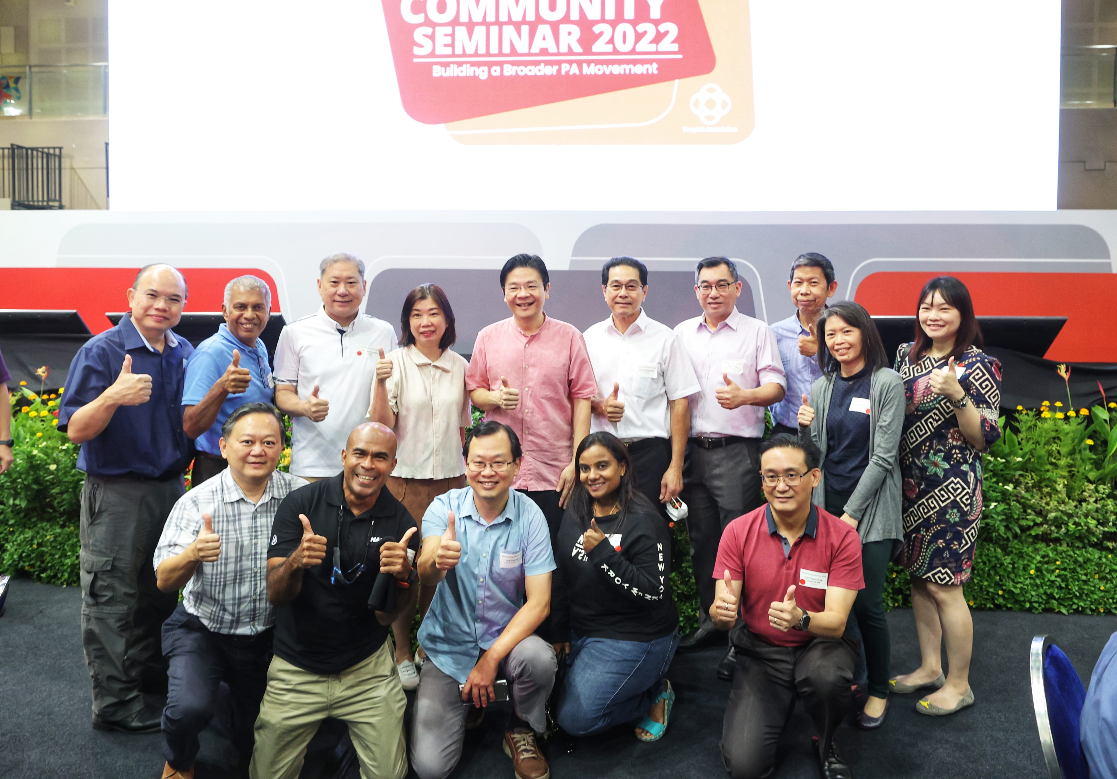 Group poses with thumbs-up in front of a "Community Seminar 2022" banner.